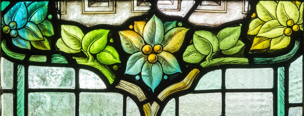 Detail of a stained glass window with leaves and berries.